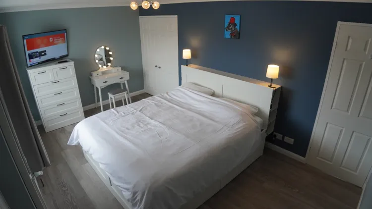 Bright bedroom with a large bed and blue feature wall